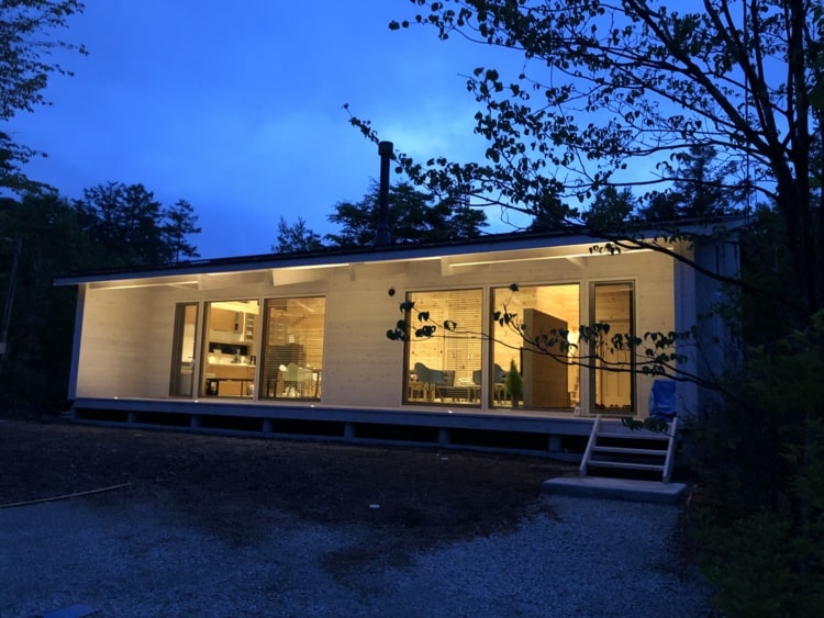 夜の明かりがともる平屋の木造住宅